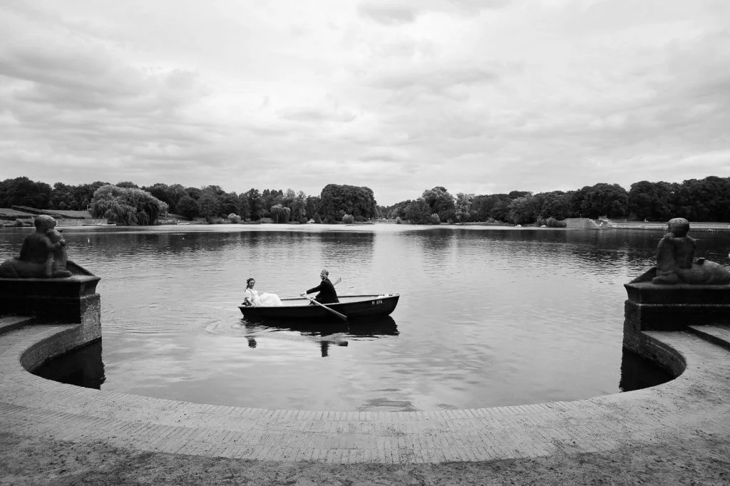 Braut und Bräutigam im romantischen Ruderboot auf dem Stadtparksee in Hamburg Winterhude bei den Brautpaarfotos beim Hochzeitsfotograf Hamburg