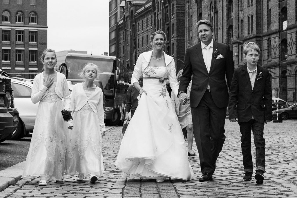 Die Hochzeitsfamilie auf dem Weg durch die Hamburger Speicherstadt. Die Hochzeitsbilder vom Hochzeitsfotograf Hamburg