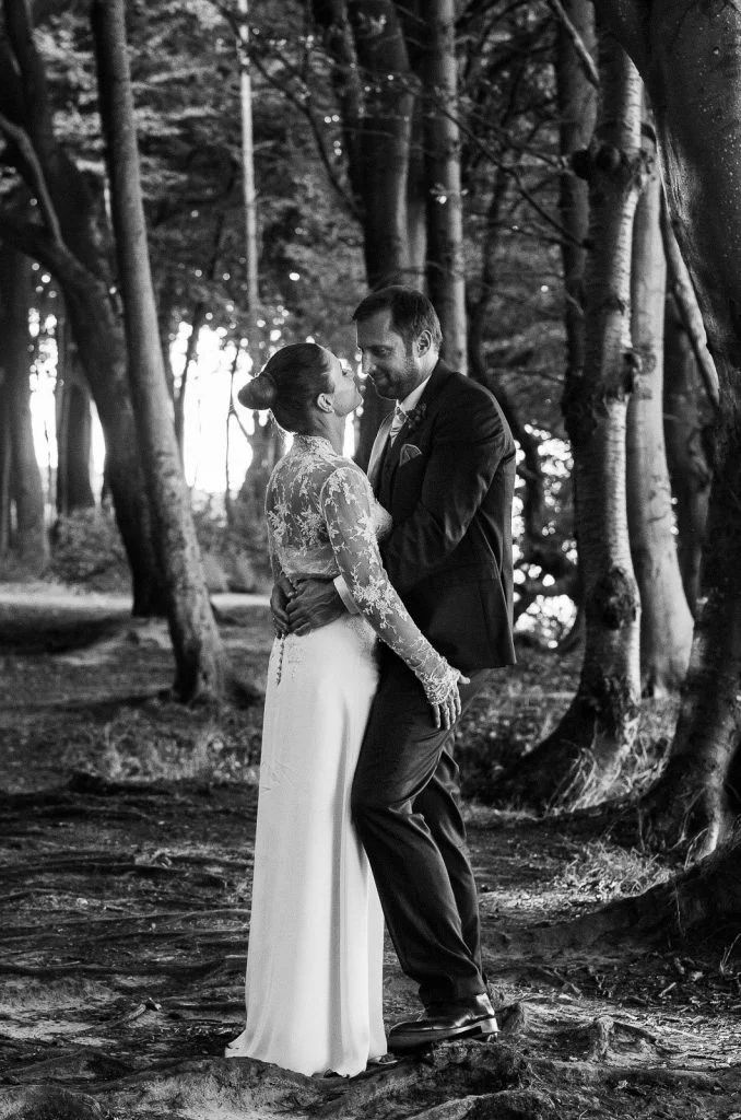 Hochzeitspaar umarmt sich bei den Brautpaarfotos am Steilufer im Märchenwald am Weissenhäuser Strand an der Ostsee beim Hochzeitsfotograf Hamburg