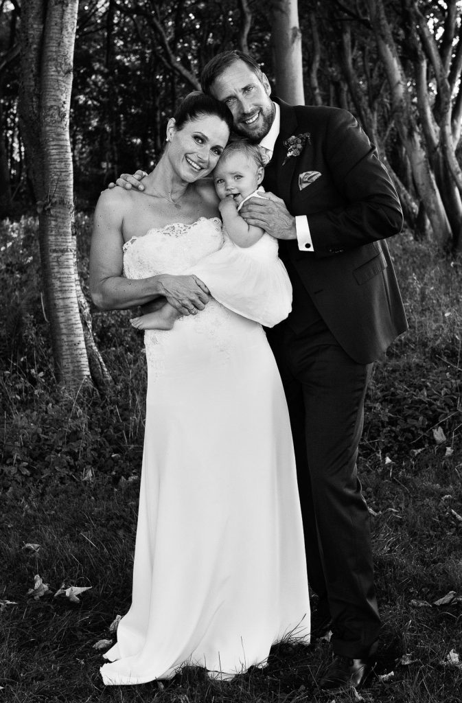Hochzeitsportrait von Braut und Bräutigam mit kleiner Tochter im Küstenwald vom Weissenhäuser Strand an der Ostsee beim Hochzeitsfotograf Hamburg