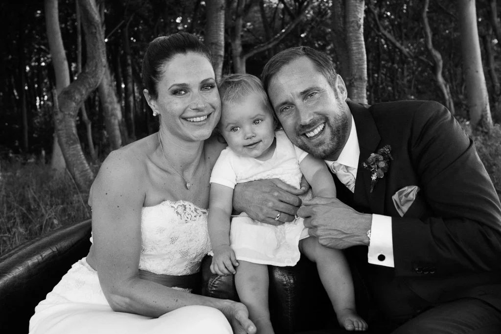 Hochzeitsfoto von braut und Bräutigam mit kleiner Tochter im Küstenwald vom Weissenhäuser Strand an der Ostsee beim Hochzeitsfotograf Hamburg