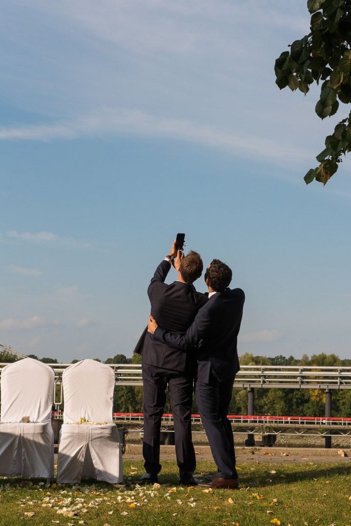 Bräutigam und Trauzeuge beim Selfie an der Villa im Jachthafen bei Hochzeitsfotografie Hamburg