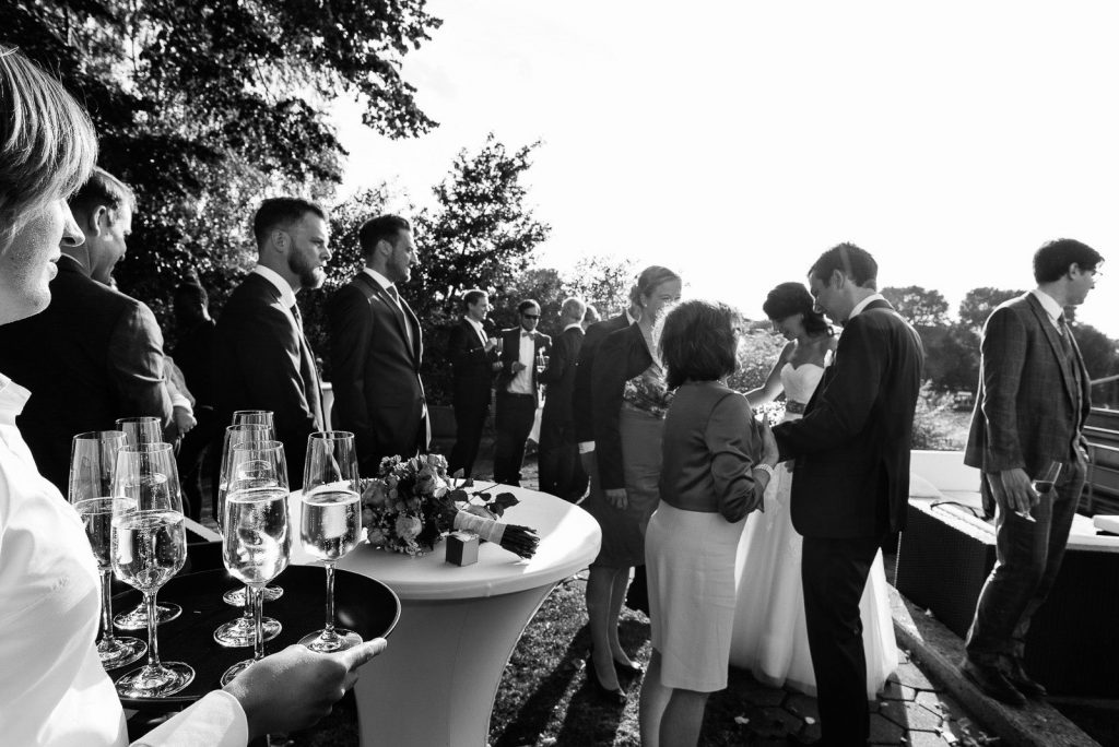 Hochzeitsgesellschaft feiert mit Sekt an der Villa im Jachthafen bei Hochzeitsfotografie Hamburg