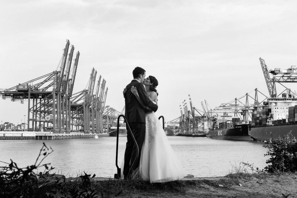 Hochzeitskuß im Parkhafen vor der Kulisse der Containerbrücken im Waltershofer Hafen bei Hochzeitsfotografie Hamburg