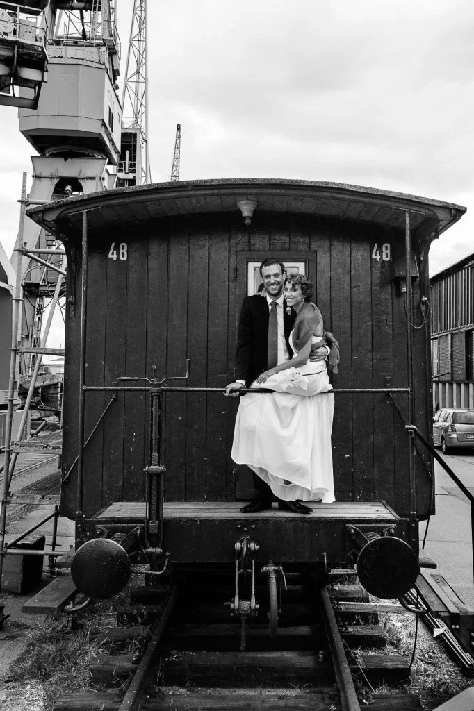 Hochzeitspaar im historischen Wagon auf den Kaianlagen des hafenmuseums HamburgHochzeitspaar schlendert über die Kaianlagen am Australiakai im Hamburger Hafen beim Hochzeitsshooting mit dem Hochzeitsfotograf Hamburg