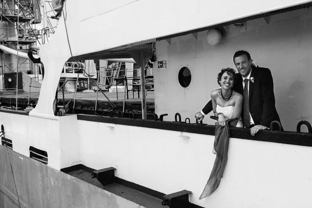 Braut und Bräutigam an der Reling des historischen Frachters MS Bleichen im Hafenmuseum HamburgHochzeitspaar schlendert über die Kaianlagen am Australiakai im Hamburger Hafen beim Hochzeitsshooting mit dem Hochzeitsfotograf Hamburg