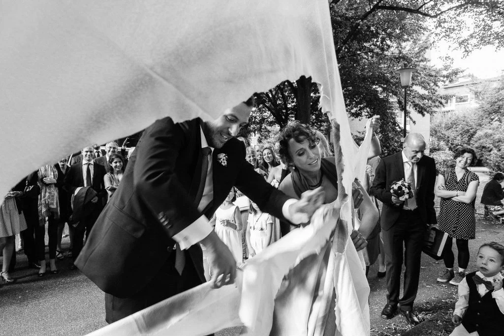 Hochzeitspaar schneidet gemeinsam ein großes Herz aus vor der Sankt Gertrud Kirche am Kuhmühlenteich in Hamburg HohenfeldeHochzeitspaar schlendert über die Kaianlagen am Australiakai im Hamburger Hafen beim Hochzeitsshooting mit dem Hochzeitsfotograf Hamburg