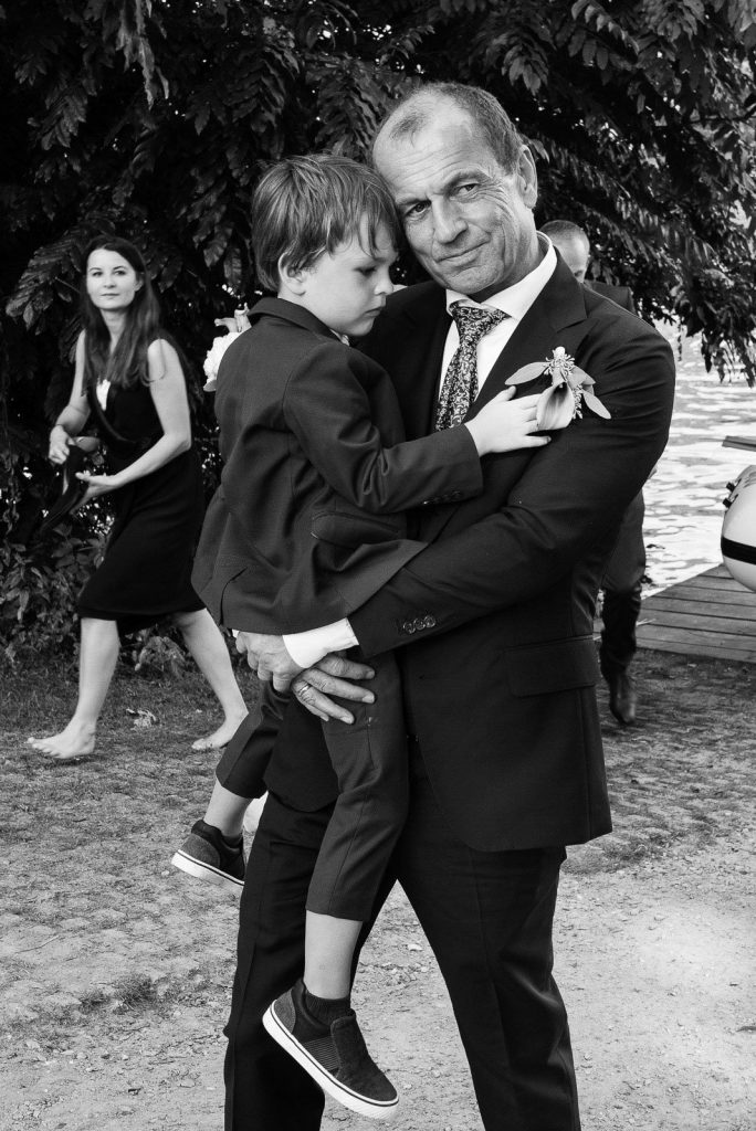 Der Bräutigam trägt seinen kleinen Sohn auf dem Arm bei den Hochzeitsfotos an der Außenalster in Harvestehude beim Hochzeitsfotograf Hamburg