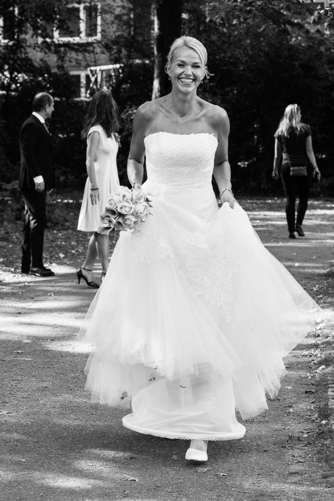 Die Braut unterwegs mit ihren Hochzeitsgästen im Eichenpark an der Alster in Harvestehude beim Hochzeitsfotograf Hamburg