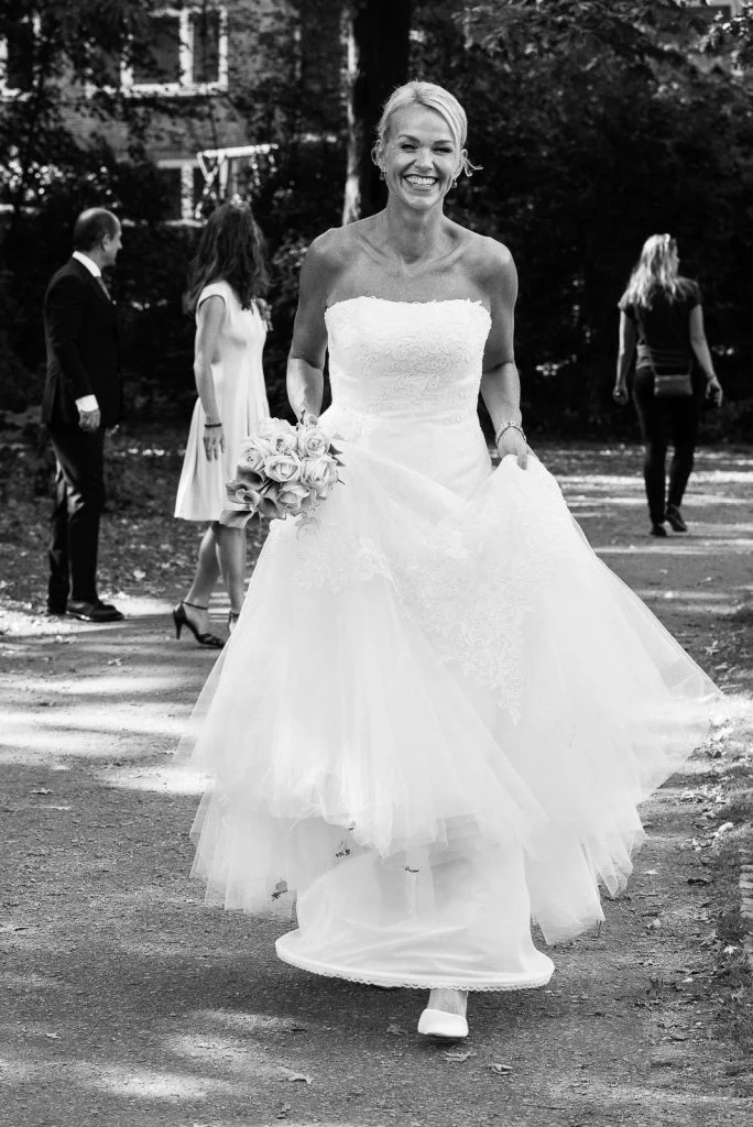 Die Braut unterwegs mit ihren Hochzeitsgästen im Eichenpark an der Alster in Harvestehude beim Hochzeitsfotograf Hamburg