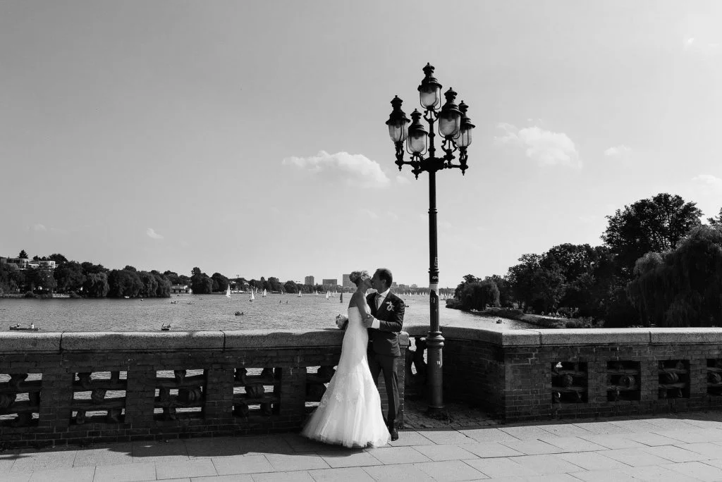 Ein Hochzeitskuß auf der Krugkoppelbrücke in Harvestehude mit Blick auf die Außenalster beim Hochzeitsfotograf Hamburg