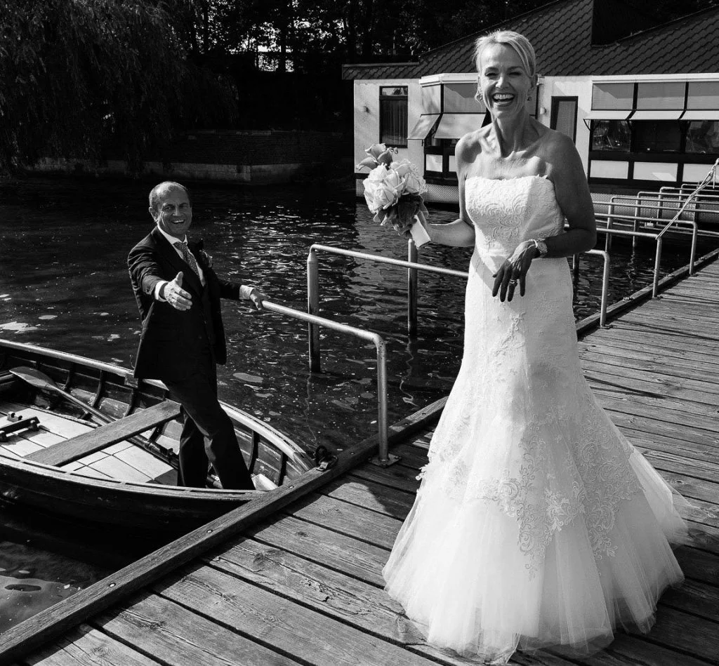 Der Bräutigam hilft seiner Braut in ein Rucerboot am Bobby Reich Bootsteg an der Außenalster in Harvestehude beim Hochzeitsfotograf Hamburg