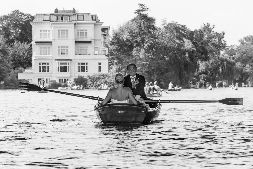 Das Hochzeitspaar beim Bootsausflug im Ruderboot auf der Außenalster an der Krugkoppelbrücke beim Hochzeitsfotograf Hamburg
