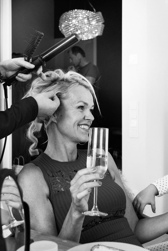 Die Hairstylistin bei der Arbeit an der Hochzeitsfrisur am Morgen des schönsten Tag im Leben beim Hochzeitsfotograf Hamburg
