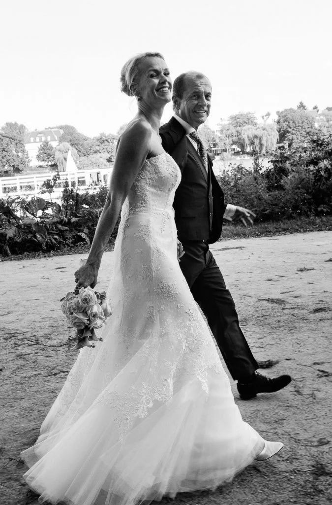 Das Hochzeitspaar bei den Hochzeitsfotos unterwegs im Alstervorland an der Außenalster in Harvestehude beim Hochzeitsfotograf Hamburg