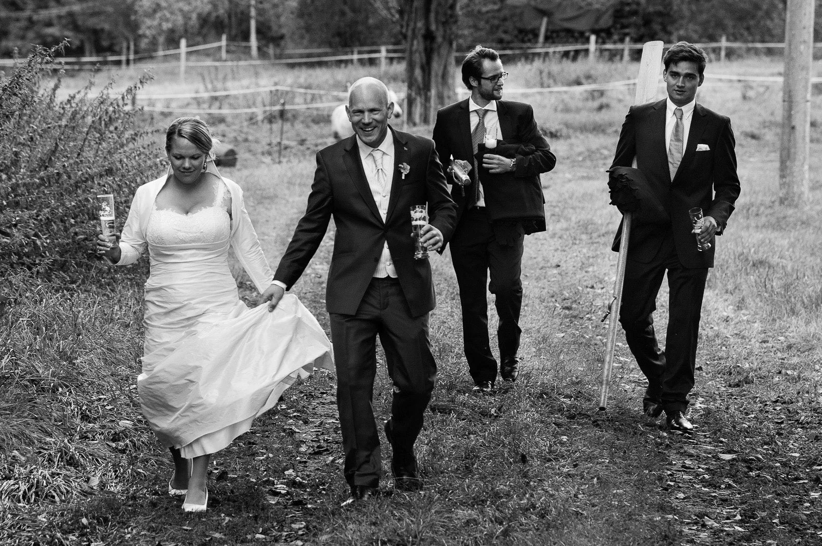 Ländliche Hochzeitsstory an der Müritz in Mecklenburg vom Hochzeitsfotograf Hamburg Hochzeitspaar mit Trauzeugen bei der Landhochzeit läuft gemeinsam über die Felder am Gutshof Woldzegarten in Mecklenburg Vorpommern beim Hochzeitsfotograf Landhochzeit Hamburg