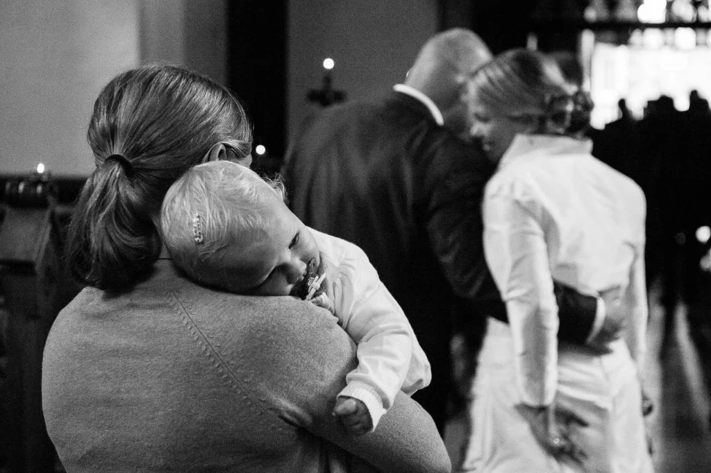 Hochzeitspaar mit Baby beim Auszug aus der Sankt Marien Kirche in Röbel an der Müritz in Mecklenburg Vorpommern beim Hochzeitsfotograf Landhochzeit Hamburg