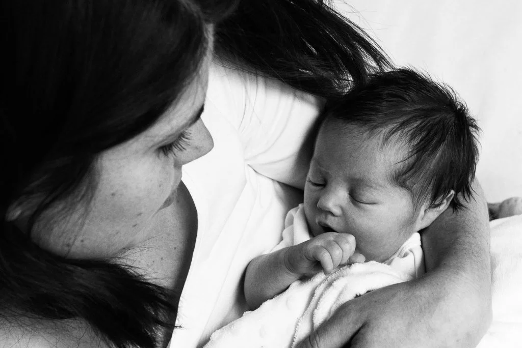 Mama hält Baby im Arm und schaut es an beim Baby Fotoshooting in Hamburg Barmbek