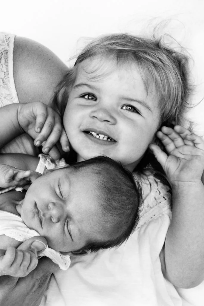 Kleine Schwester und schlafendes Baby beim Baby Fotoshooting in Hamburg Niendorf