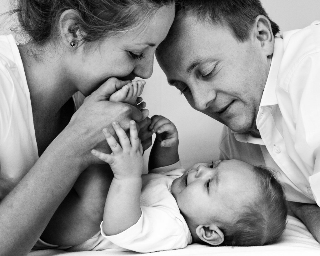 Baby kuschelt mit Mama und Papa beim Baby Fotoshooting in Hamburg Poppenbuettel
