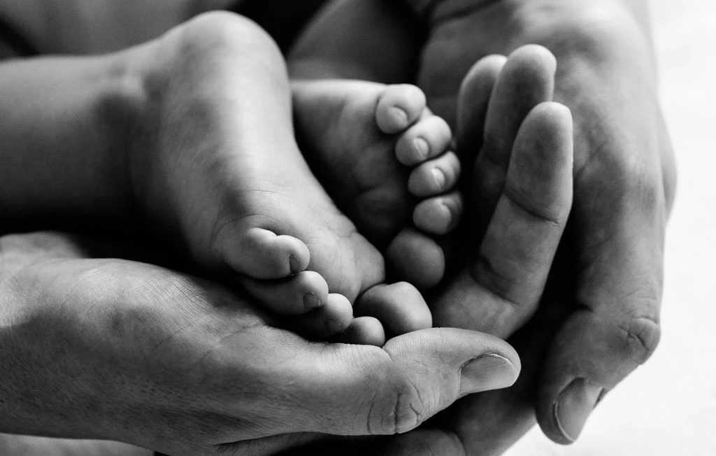 Babyfüsse liegen in den Händen der Mutter beim Baby Fotoshooting in Hamburg Eppendorf