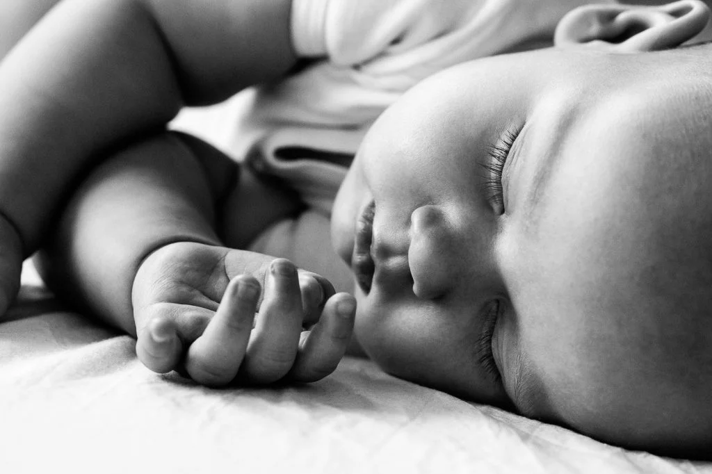 Baby liegt auf dem Bett und schläft beim Baby Fotoshooting in Hamburg Eppendorf
