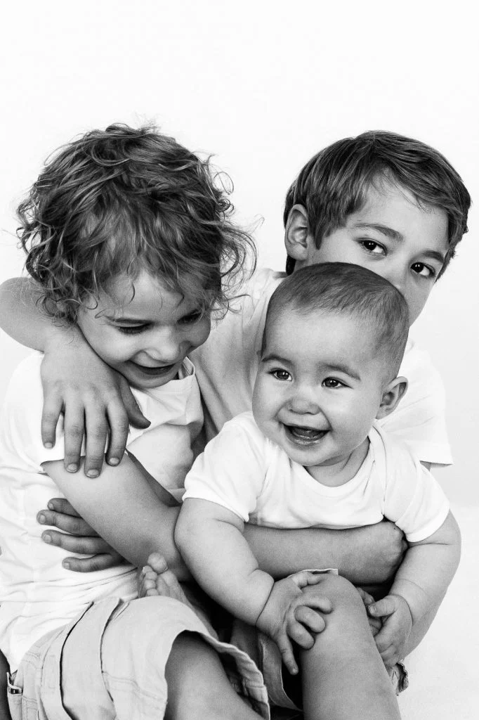 Geschwister halten Baby auf dem Arm beim Baby Fotoshooting in Hamburg Eimsbüttel