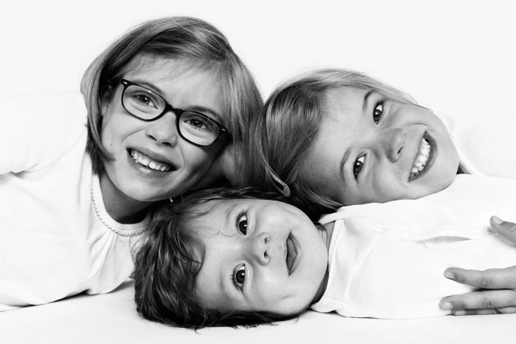 Geschwister kuscheln mit Baby beim Baby Foto Shooting in Hamburg Eppendorf