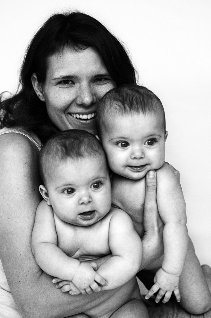 Mama kuschelt mit ihren Zwillingen im Arm beim Baby Fotoshooting in Hamburg Neustadt