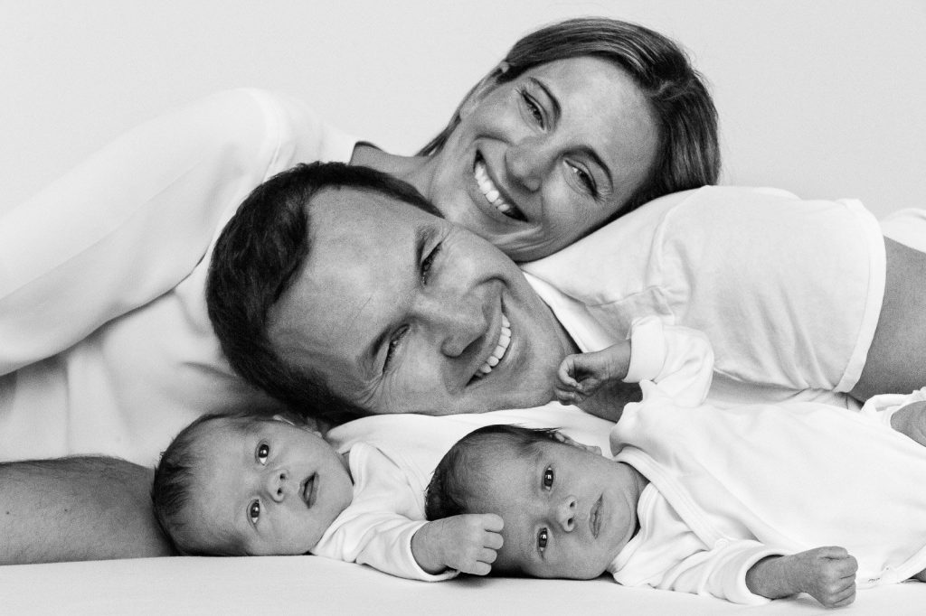 Mutter, Vater und ihre Zwillinge liegen gemeinsam auf der Decke beim Baby Fotoshooting in Hamburg Barmbek