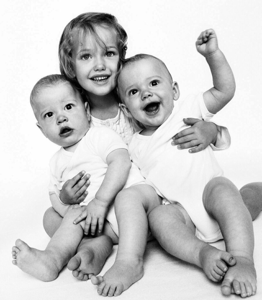 Geschwisterkind mit Zwillingen im Arm beim Baby Fotoshooting in Hamburg Langenhorn