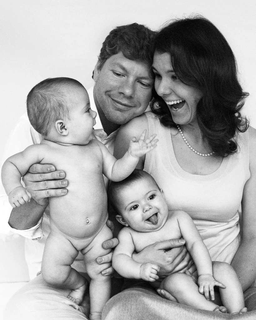 Eltern spielen mit ihren Zwillingen und ein Baby streckt die Zunge raus beim Baby Fotoshooting in Hamburg Neustadt