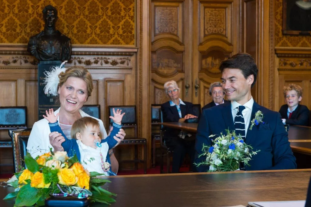 Das Hochzeitspaar mit Hochzeitskind lauscht der Rede der Standesbeamtin im Phönixsaal vom Hamburger Rathaus beim Hochzeitsfotograf Hamburg