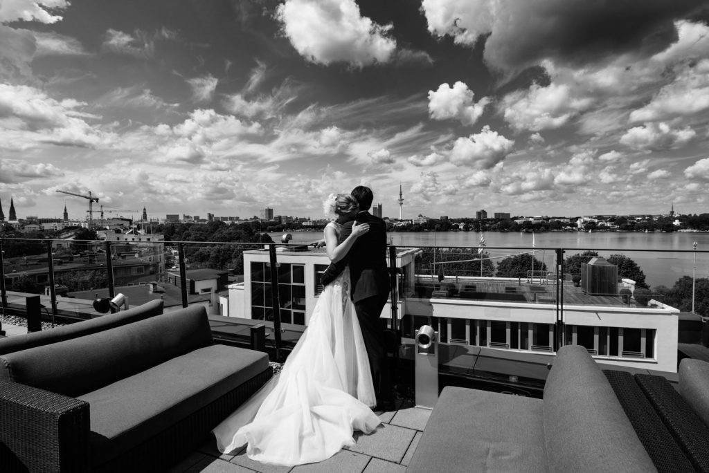 Das Hochzeitspaar genießt den Panorama Blick über die Aussenalster von der Dachtersse vom Hotel The George in Sankt Georg beim Hochzeitsfotograf Hamburg