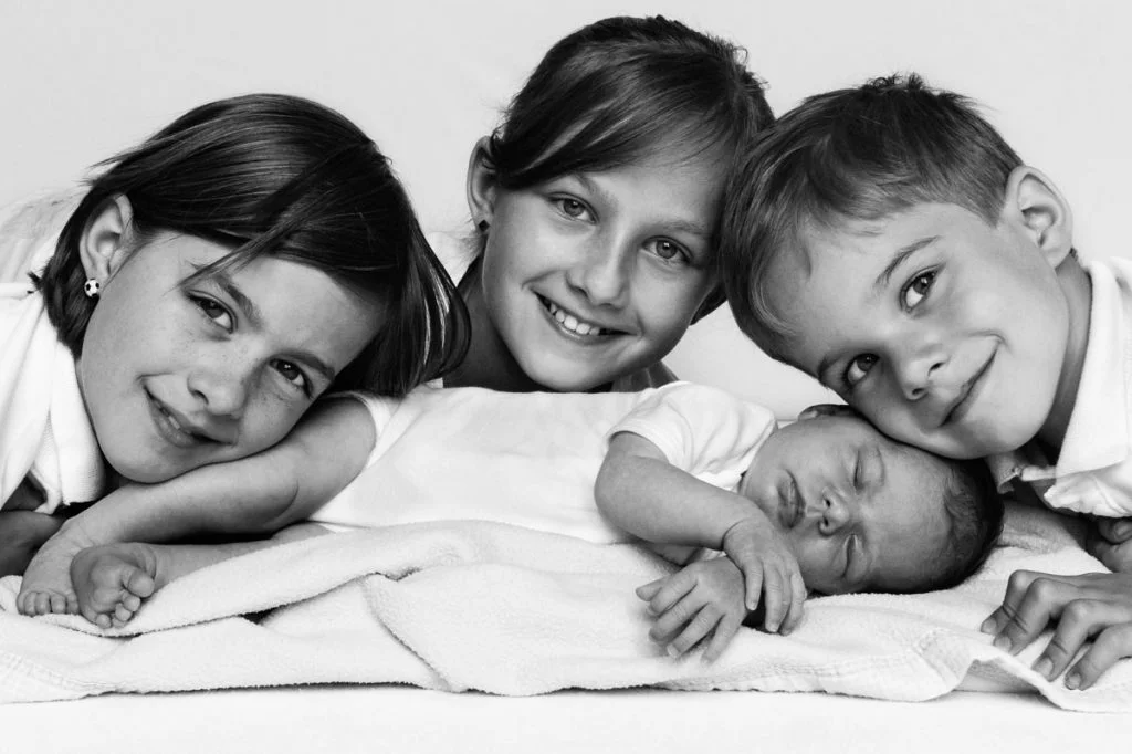 Geschwister kuscheln mit Baby beim Baby Foto Shooting in Hamburg