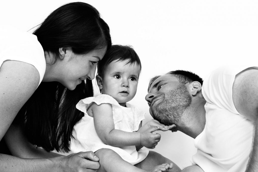 Baby kuschelt mit Mama und Papa beim Baby Fotoshooting zuhause in Hamburg