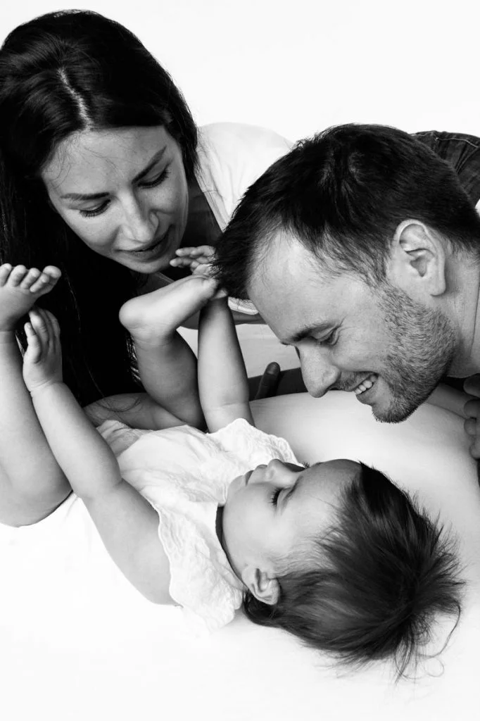 Baby spielt mit Mama und Papa beim Baby Fotoshooting zuhause in Hamburg