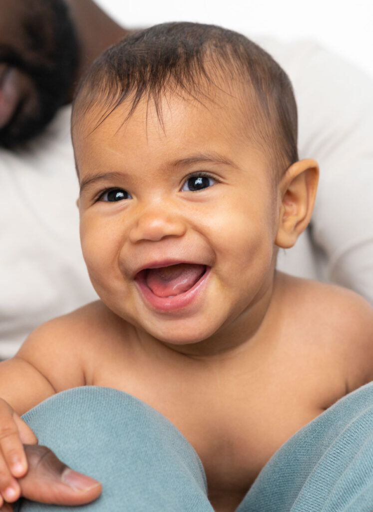 Lachendes Babygesicht beim Baby Fotoshooting mit dem Tageslicht zuhause in Hamburg