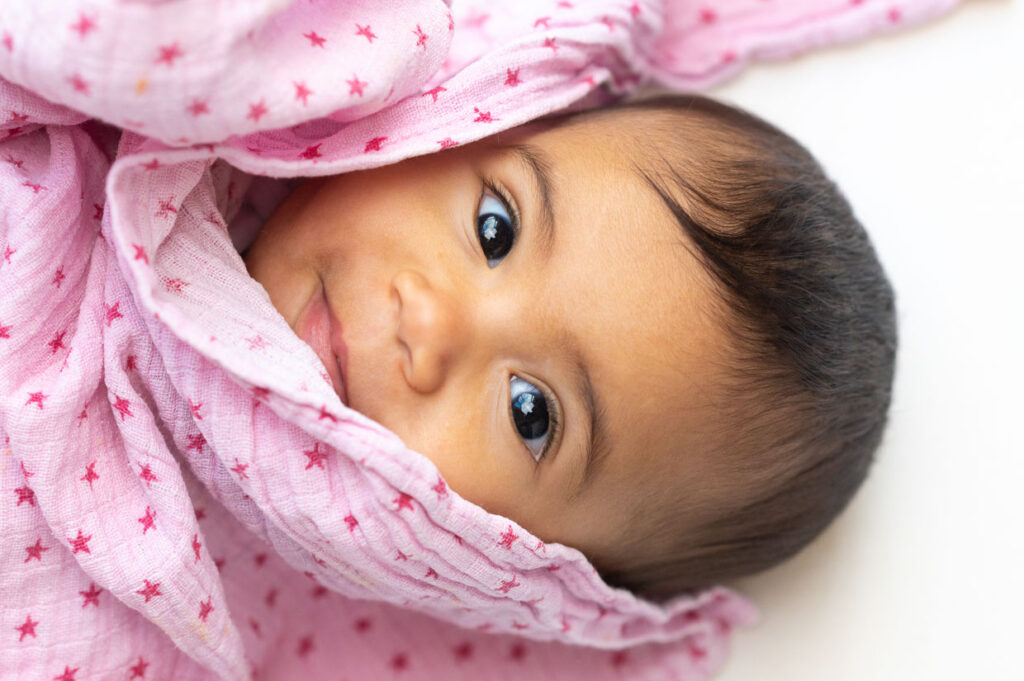 Lachendes Babygesicht beim Baby Fotoshooting mit dem Tageslicht zuhause in Hamburg