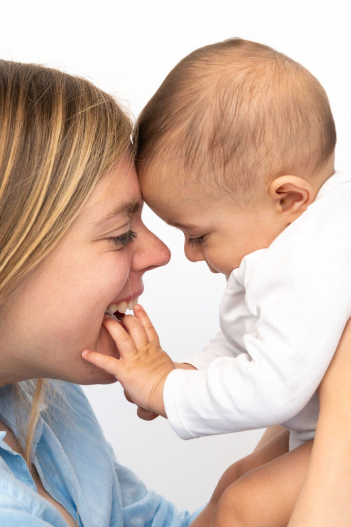 Baby kuschelt mit Mama beim Baby Fotoshooting und der Babyfotografie zuhause in Hamburg Altona